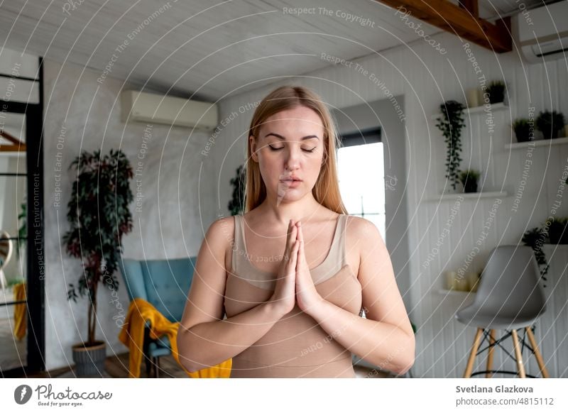 Blonde woman. Girl with closed eyes folded hands in namaste gesture and meditates in yoga class Mental Health care Wellness Myofascial relaxation activity