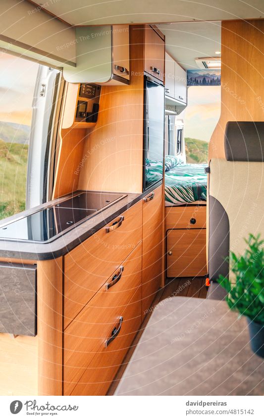 Interior of a camper van with kitchen and bed interior indoor drawer home seat nobody clean vacation campervan vehicle camping cozy kitchen counter fridge car