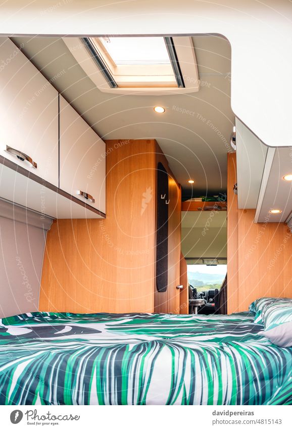 Interior of a camper van with double bed interior indoor skylight cabinet pillow home cozy nobody clean comfortable vacation bed linen tropical campervan