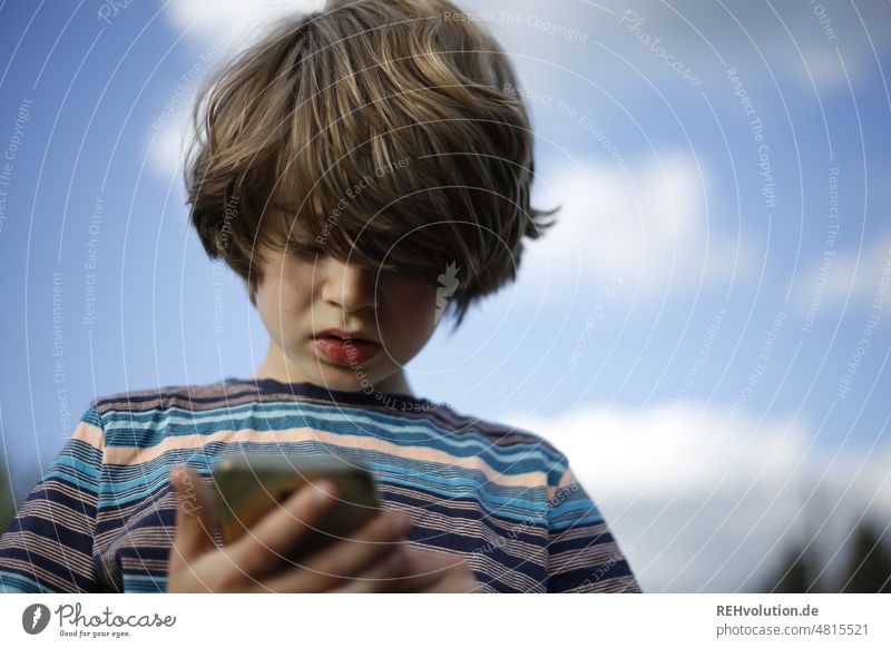 Boy looking at a smartphone Infancy Equipment digital device whatsapp Media usage media pedagogy upbringing Child Boy (child) Cellphone Digital Concentrate