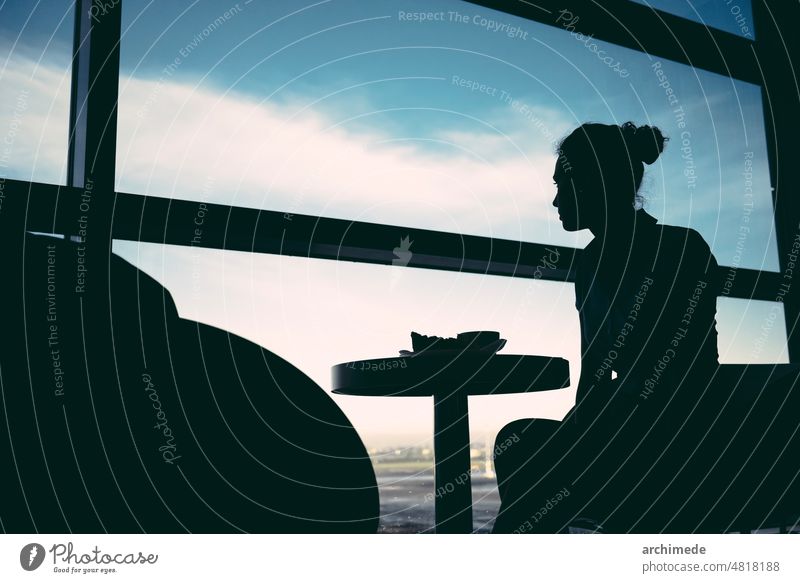 Woman waiting at airport lounge travel journey woman silhouette departures arrival hostess table seat sitting lifestyle transport transportation traveling