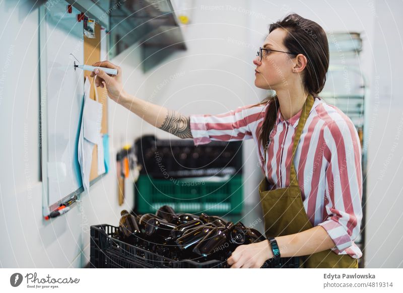 Woman working in a small food manufacturing company apron worker factory production employee skill staff workplace workshop craft back office industry job