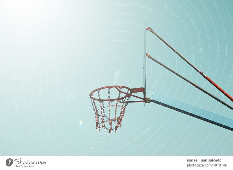 street basket hoop and blue sky background basketball silhouette circle chain metallic net sport sports equipment play playing playful old park playground