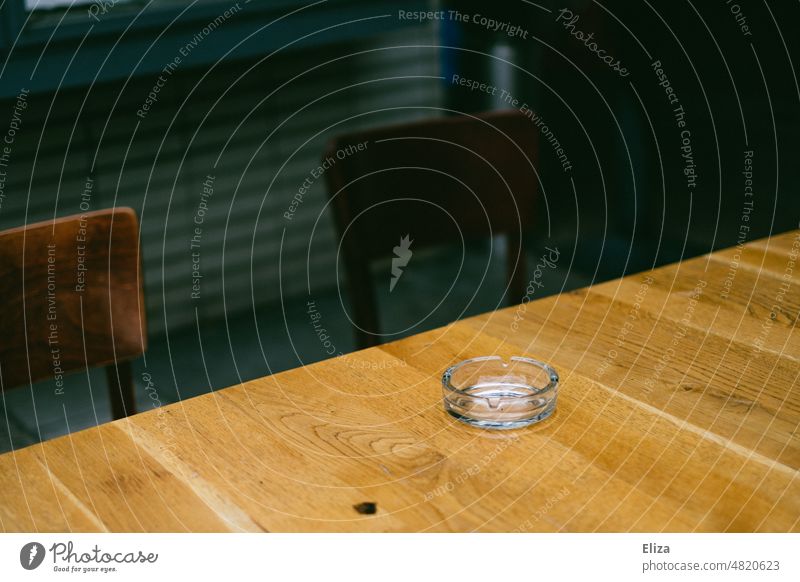 [hansa BER 2022] Empty glass ashtray on a wooden table Ashtray Table Wooden table Gastronomy Smoking diagonal Glass chairs two Deserted Café Restaurant
