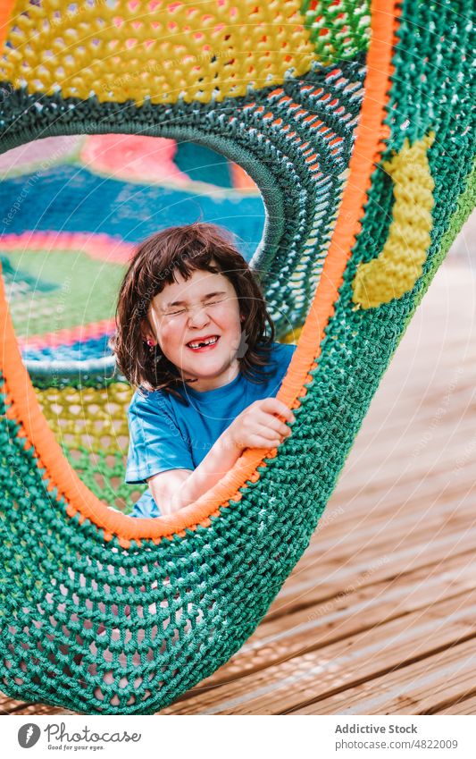Happy cute child with closed eyes lying inside of colorful hammock relax eyes closed park happy enjoy girl smile knitted carefree portrait adorable content glad