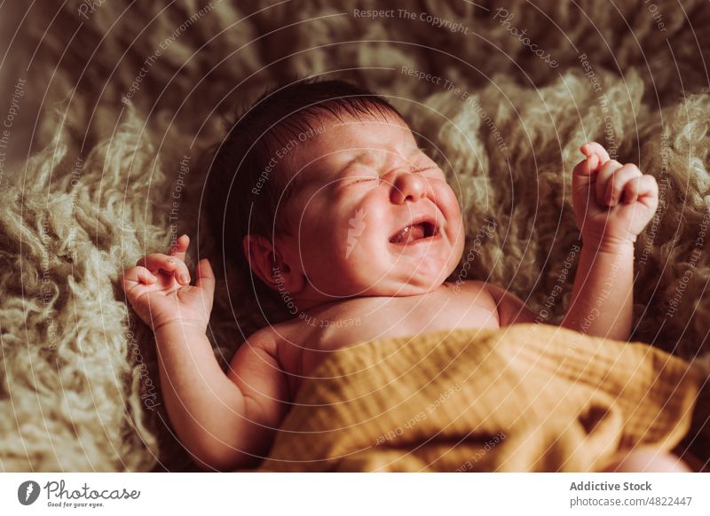 Cute baby lying on fur blanket and crying eyes closed adorable innocent upset newborn babyhood comfort sweet bedroom infant expressive plaid childhood cute calm