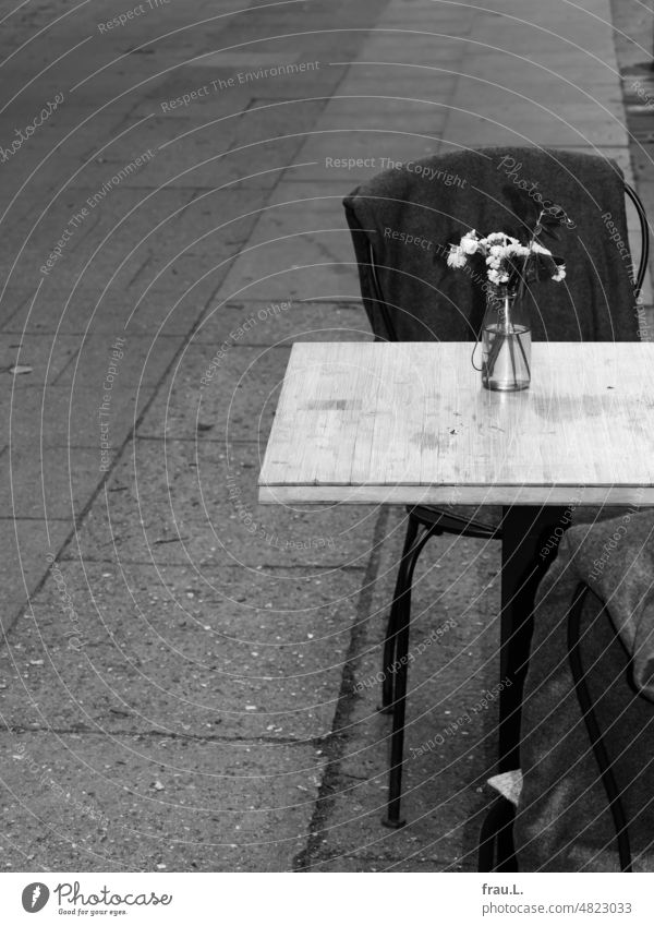 Table with bouquet Sidewalk café Decoration Blossom Plant Flower Bouquet Chair Wool blanket Bistro Café Gloomy bleak Town urban Bakery shop Restaurant