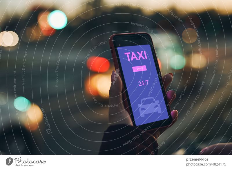 Woman ordering taxi online using mobile app on smart phone. Booking taxi using application online. Arranging taxi ride in downtown city street. Car sharing. Taxi service on mobile