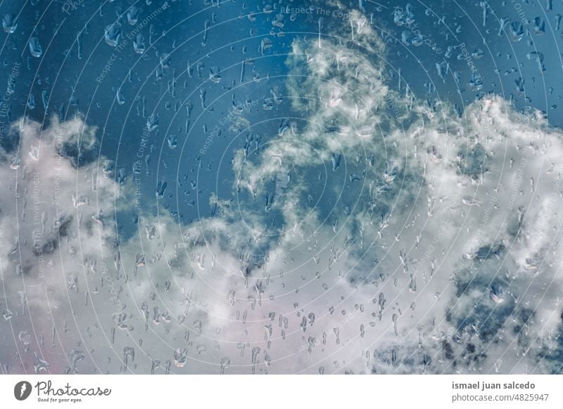 drops on the window and blue sky background raindrops water wet glass clouds transparent surface closeup abstract textured bright rainy rainy days condensation