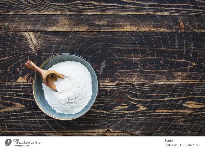 Flour in a rustic bowl on a brown wooden table Rustic Wooden table Brown moody plan Baking Nutrition Colour photo Bread Preparation Grain White Ingredients