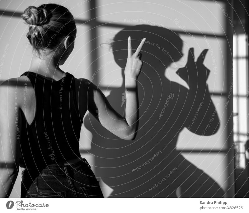Portrait of a young woman with her shadow makes the Victory sign portrait Young woman Shadow victory Human being Feminine Long-haired naturally 18 - 30 years