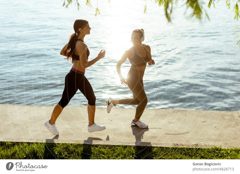 Young woman taking running exercise by the river promenade action active activity adult athlete athletic beautiful caucasian city exercising female fit fitness