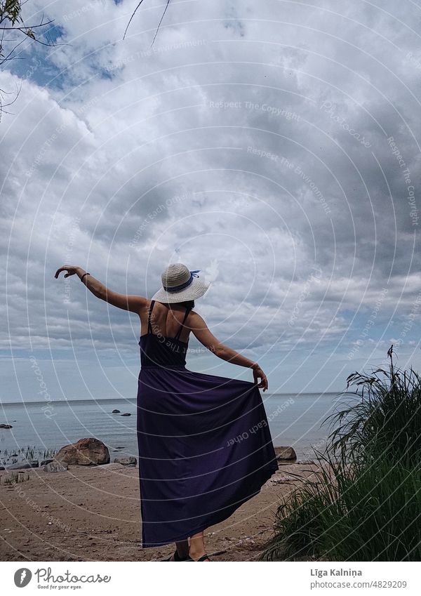 Woman dancing in a dress Movement Summer vacation Loneliness Scene Destination scenery Copy Space exploration summer hat Dress Fashion Purple Beach