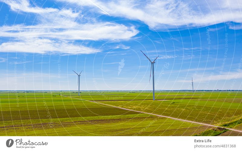 View on several windmills, wind generators, turbines, producing renewable clean energy by converting kinetic energy Above Agricultural Agriculture Alternative
