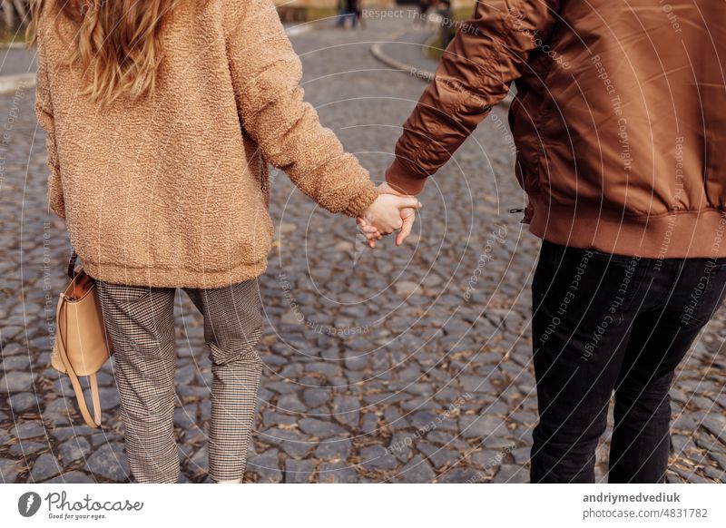 Cropped photo of a young loving couple walking by street outdoors holding hands of each other. cropped love together two woman lifestyle happy summer park