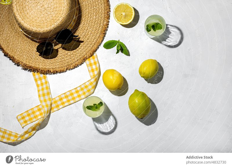 Flat lay of summer concept composition lemon fresh natural healthy creative organic sunglasses drinks hat yellow color shadow shade sunlight mint bright fruit