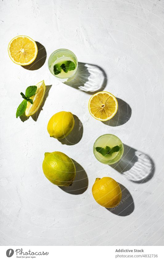 Flat lay of summer concept composition lemon fresh natural healthy organic glasses drinks yellow shadow shade sunlight mint bright fruit food arrangement season