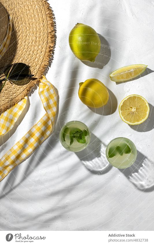 Flat lay of summer concept composition lemon fresh natural healthy creative organic sunglasses drinks hat yellow color shadow sunlight mint bright fruit vivid