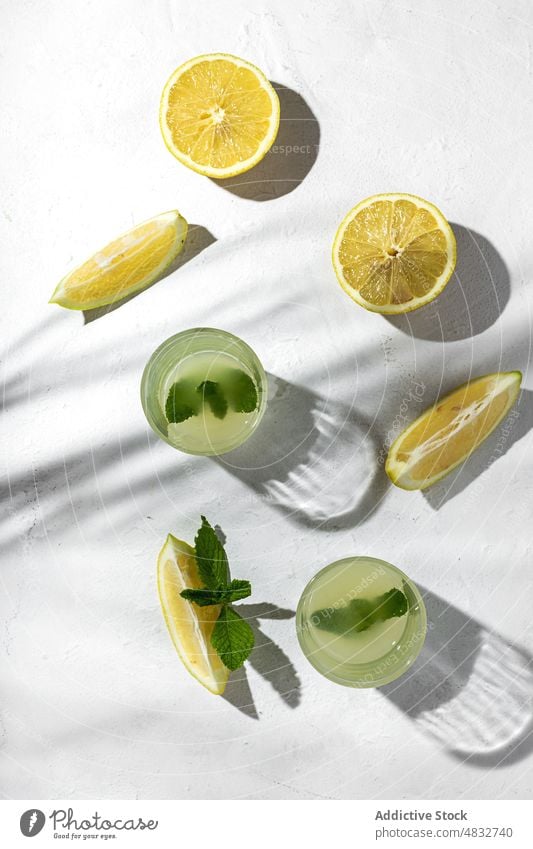 Flat lay of summer concept composition lemon fresh natural healthy organic glasses drinks yellow shadow shade sunlight mint bright fruit food arrangement season
