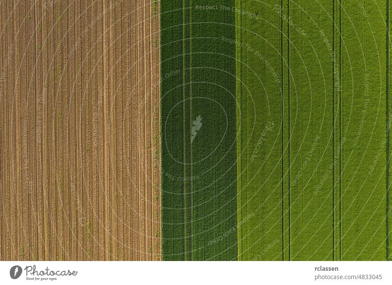 Aerial top view of a different agriculture fields in countryside on a spring day. Drone shot aerial farm drone farmland plowed wheat corn photo crops modified