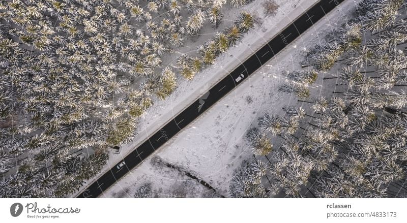 Aerial view of snowy forest with a road and car. Captured from above with a drone winter aerial sunset sunlight flight day adventure background beautiful bird