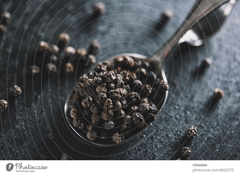 Black pepper corns on a spoon black spice ground powder peppercorn white aroma aromatic bowl condiment dry exploding flavor food herb ingredient kitchen milled