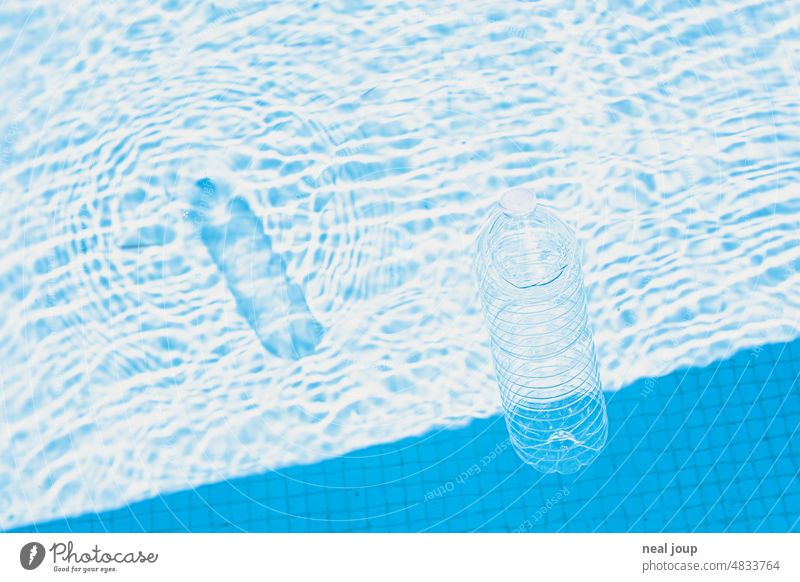 Transparent plastic bottle and its graphic shadow in bluish shimmering pool full of summer atmosphere Water water structure graphically Bottle of water
