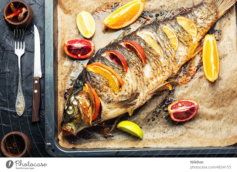 Whole baked carp with citrus fruits. fish lemon roasted seafood oranges grilled dinner lunch fried delicious diet gourmet tasty kitchen baking sheet prepared