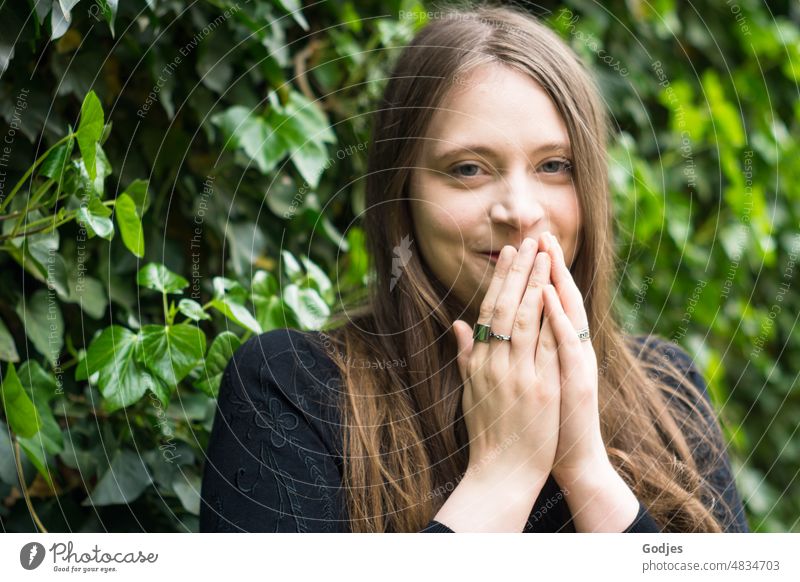 Portrait of shy young woman against green background portrait Young woman Woman Feminine Face Human being pretty Long-haired naturally Authentic Exterior shot