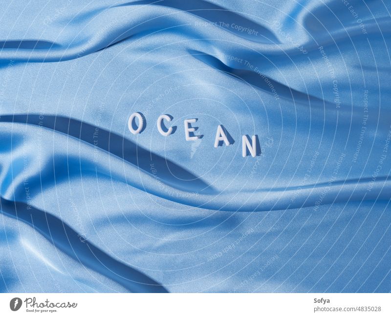World ocean in white letters on blue wave textile day word world water 8 june surface concept sea holiday earth protection underwater international flat lay