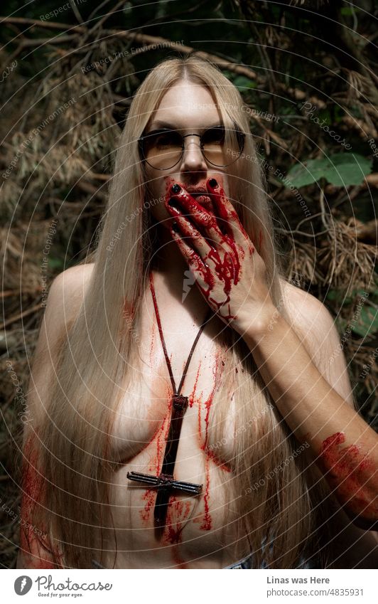 Some satanic rituals might be happening in these woods. With a naked blonde girl covered in blood. Wearing her sunglasses casually. Oh, and don’t forget a cross made from nails. Or maybe it’s all just for fun and for an alternative music festival.