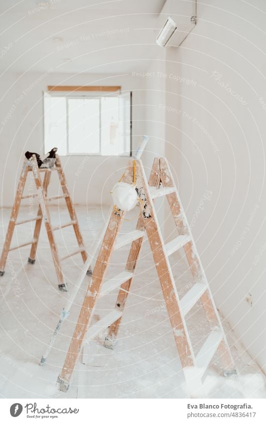 ladders on white room at construction site. Painting walls. Home improvement, renovation works home house colors interior roller grey painting new industry copy