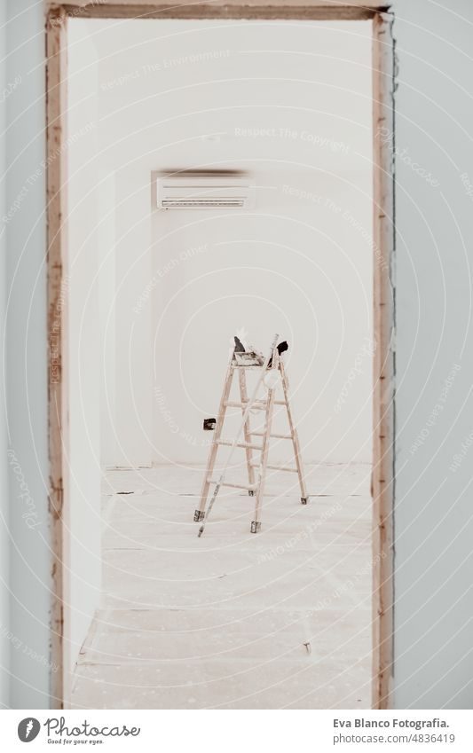 ladder on white room at construction site. Painting walls. Home improvement, renovation works home house colors interior roller grey painting new industry copy