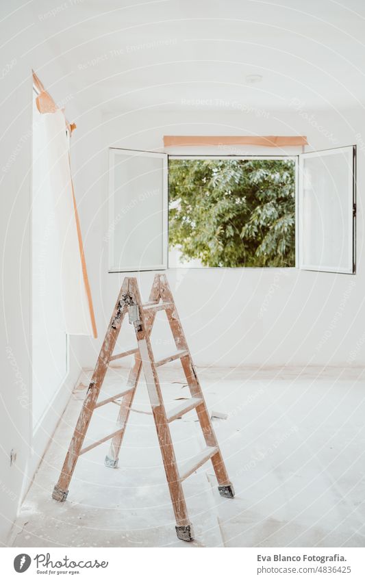 ladders and painter tools on white room at construction site. Painting walls. Home improvement works renovation home house colors interior roller grey painting