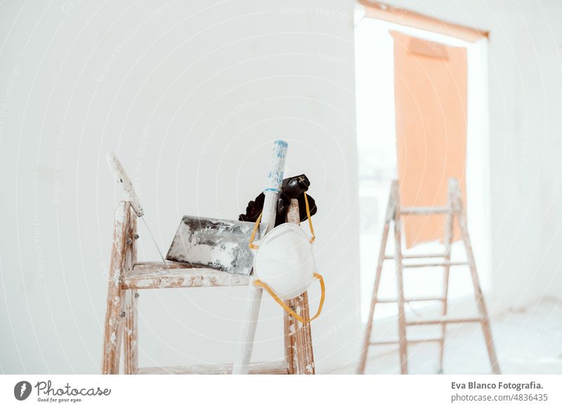 ladders and tools on white room at construction site. Painting walls. Home improvement, renovation works home house colors interior roller grey painting new