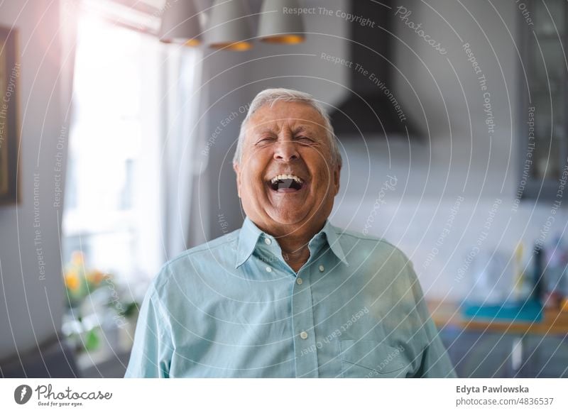 Happy senior man laughing in his home senior adult older aged portrait person casual leisure lifestyle pensioner caucasian retired people mature retirement