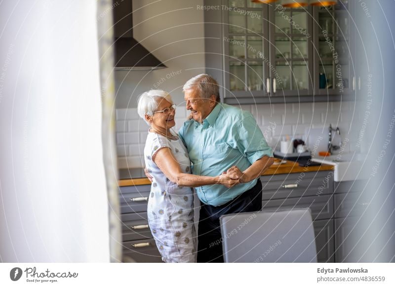 Senior Couple Dancing in their Kitchen senior adult older aged portrait person casual leisure lifestyle pensioner caucasian retired people mature retirement