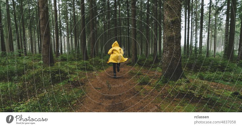 man in yellow rain jacket runs in the forest, fog, rain and mist autumn raincoat evil fairytale fear hike hiking lonely mood path traveler wildlife woodland
