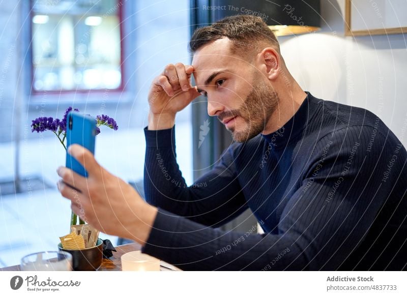 Man talking selfie in cafe man self portrait smartphone style social media hobby photography capture modern table cellphone mobile handsome male cafeteria
