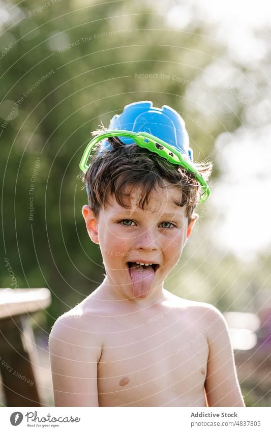 Funny boy with bucket in head child kid childhood summer cute adorable innocent shirtless toddler joy little playful cheerful happy fun smile garden outdoors