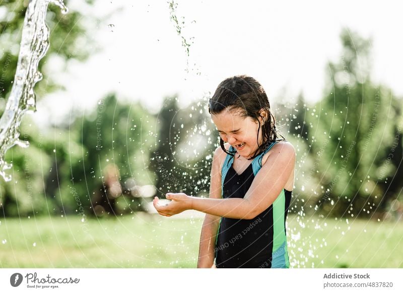 Wet girl smiling in park summer female wet meadow nature sportswoman happy healthy droplets positive lawn cheerful relax lifestyle rest smile blurred background