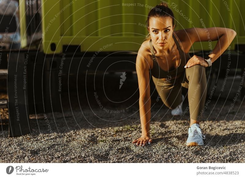 Young woman in sportswear exercising at urban environment active arab arabic athletic beautiful caucasian energy exercise female fit fitness flexibility healthy