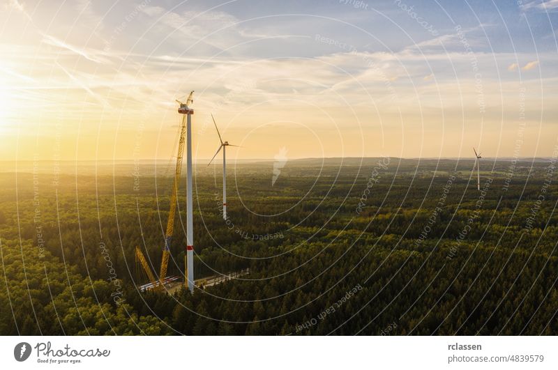 Wind turbines under construction in the forest - Energy Production with clean and Renewable Energy - aerial shot wind energy power environment fuel alternative