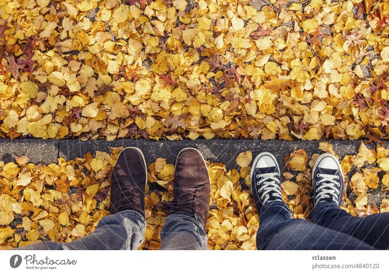 young man and his girl friend stands on a curbside at autumn, high angle footsie or flortrait, personal pespective from above. pov people lifestyle point view