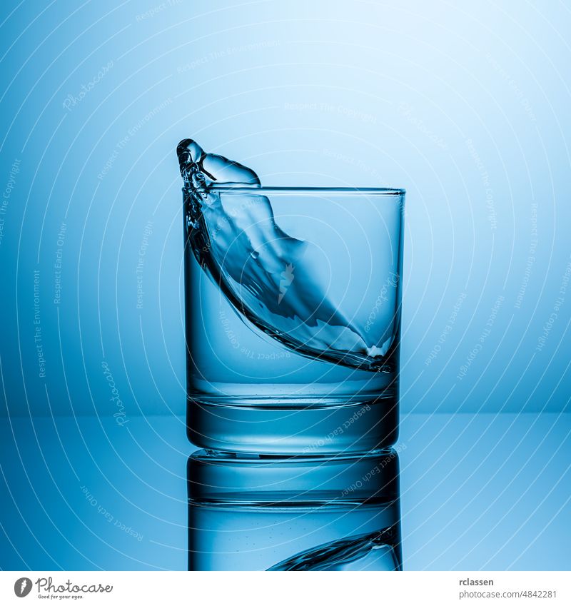 Splashing water in glass drinking water nutrition mineral water tap water beverage thirst blue fresh healthy freshwater cold nature purity raw material clean
