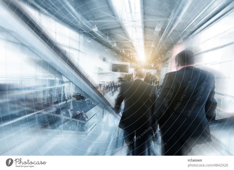 Blurred business people using a escalator on a  trade fair / messe architecture visitors moving berlin corridor frankfurt dusseldorf group cologne blur germany