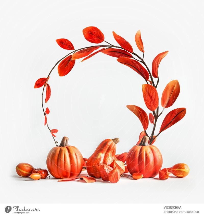 Autumn composition with pumpkins and curved leaves branch in circle shape at white background. autumn seasonal fall concept front view copy space frame red