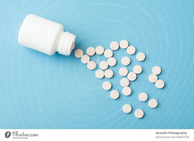 White plastic bottle and pills on blue background. antibiotic business capsule care chemistry clinic close up concept container corona coronavirus covid 19 cure