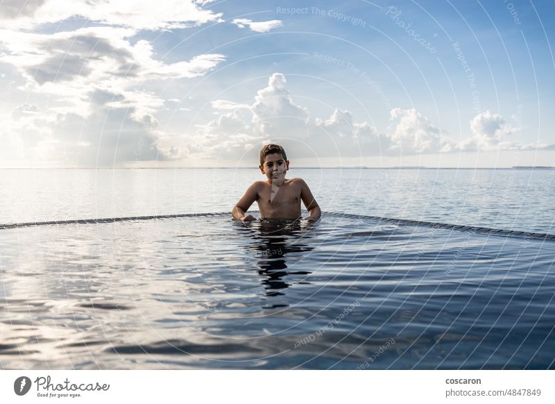 Little kid swimming on a pool of a hotel resort active people alone beach blue boy caucasian cheerful child childhood cute fun happiness happy have fun infinity