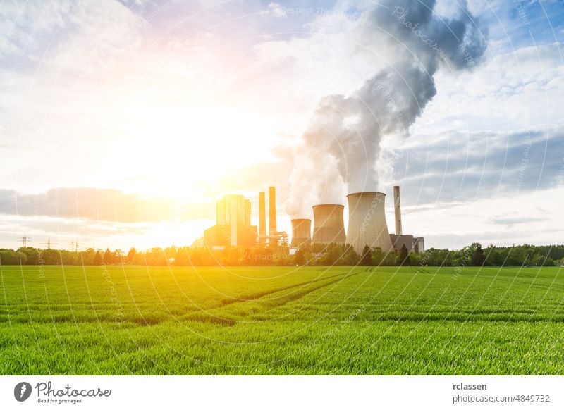 lignite power plant with bright sunlight and cloudy sky energy mix coal renewable solar wind blue brown carbon clouds change chimney climate co2 cooling dioxide